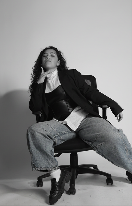 Black and white portrait of a woman seated sideways on an office chair
